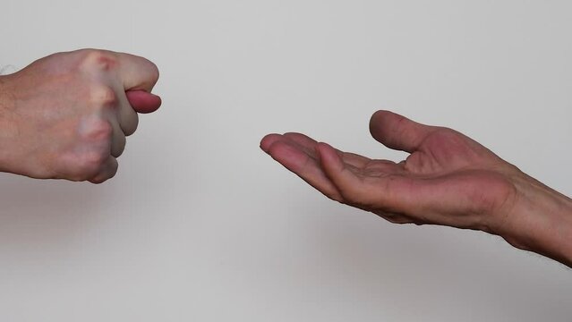 the hand of a man shows figs to the palms of an old man begging for alms. concept greed, indifference. gesture from the fingers of the hand is not ladies.deception of old people