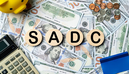 SADC text in wooden circle on Banknotes background, credit card, piggybank, calculator. Southern...