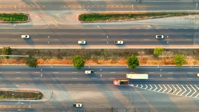 Aerial top view of the highway at sunset is a breathtaking sight, a mesmerizing blend of natural and man-made beauty that captures the imagination and stirs the soul. Transportation concept. 4K Drone
