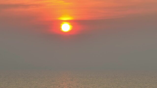 The drone captures the sun is rising above the sea, interplay of light and shadow, revealing the gentle waves. It's a breathtaking sight that fills the heart with peace and wonder. Aerial view. 4K
