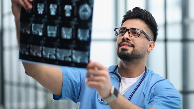 Confident doctor with x-ray picture in office