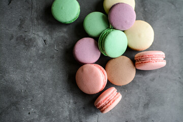 Colorful and sweet macaroon cookies on dark background