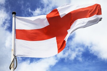 Low angle shot of an England flag waving on a pole in the sky