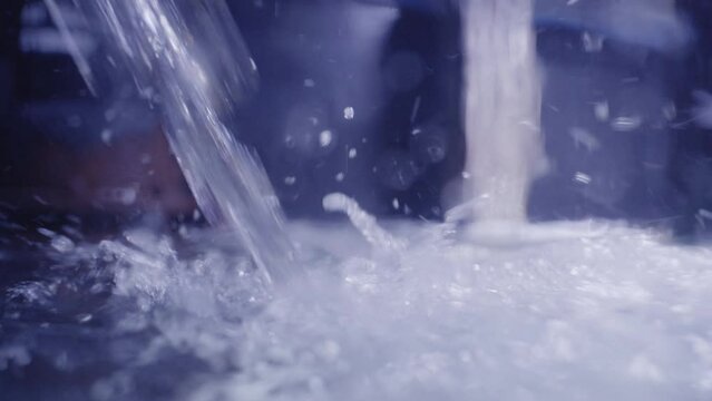 Freshly filtered water splashes while filling tank at a treatment plant.