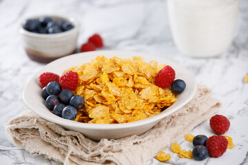 Tasty cereal with blueberries and raspberries on a marble table