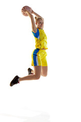 Motivated, concentrated young girl in motion, jumping with ball, playing basketball against white...