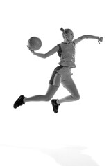Fototapeta na wymiar Black and white image of young sportive girl during basketball game, playing, training against white studio background. Concept of professional sport, hobby, healthy lifestyle, action and motion