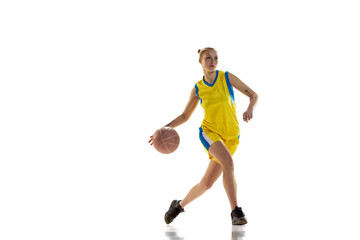 Naklejka na ściany i meble Competition. Young sportive girl, basketball player in uniform training, playing against white studio background. Concept of professional sport, hobby, healthy lifestyle, action and motion