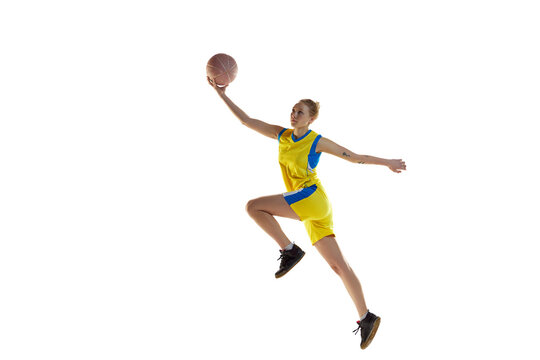Dynamic image of young competitive young girl during basketball game, playing, training against white studio background. Concept of professional sport, hobby, healthy lifestyle, action and motion