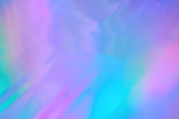 Blurred ethereal pastel neon pink, purple, mint blue holographic metallic foil background texture. Abstract futuristic disco, rave, festive dreamlike backdrop, Lo-fi multicolor vintage retro design