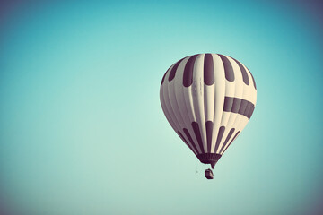 Fototapeta premium Flying hot air balloon against bright blue sky