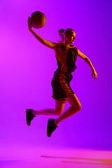 Obraz premium Full-length dynamical image of young female basketball player, girl training with ball against white studio background. Concept of professional sport, hobby, healthy lifestyle, action and motion