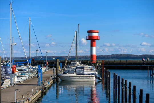Kleiner Leuchtturm mit Booten am Hafen an der Ostsee