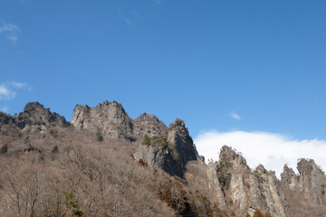 Fototapeta na wymiar 早春のゴツゴツした妙義山と白い雲