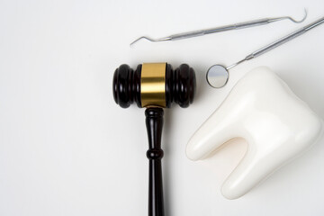Dental insurance concept. White tooth and judge gavel
