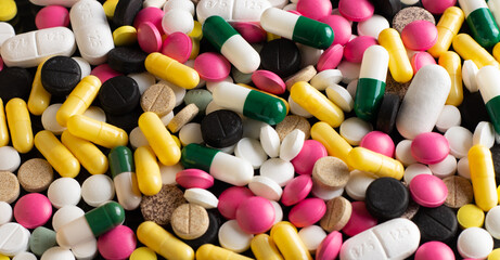 Various medical drugs, antibiotics and vitamins are scattered on the table.