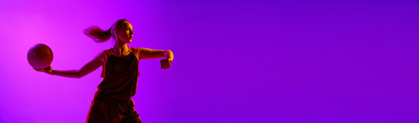 Young concentrated girl, female basketball player in motion, training, playing against white studio background. Professional sport, hobby, healthy lifestyle, action concept. Banner. Copy space for ad