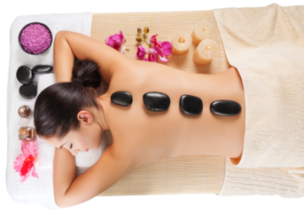 Beautiful young woman receiving hot stone massage at salon spa