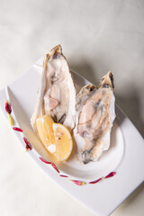 fresh western seafood raw big oyster shell with lemon in white cold plate on wood table luxury halal food fine dining restaurant menu