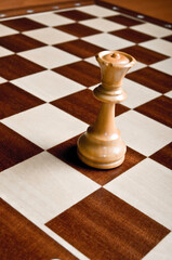 chess piece of Queen on an empty chessboard