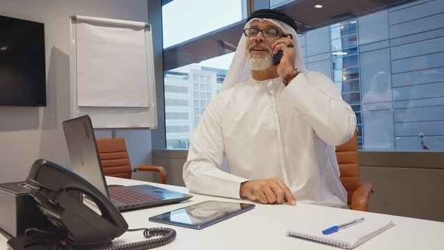 Business team at work in a office in Dubai. Locals from united arab emirates working on a new project wearing the formal traditional white outfit