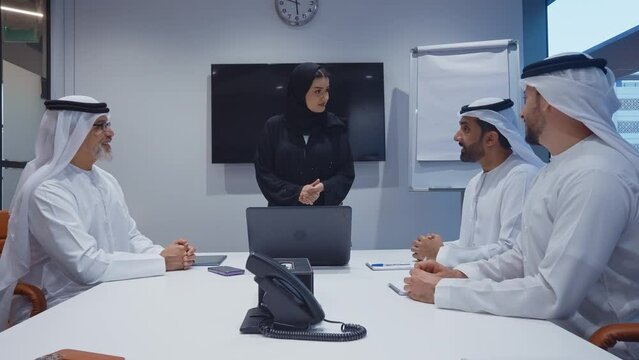Business team at work in a office in Dubai. Locals from united arab emirates working on a new project wearing the formal traditional white outfit