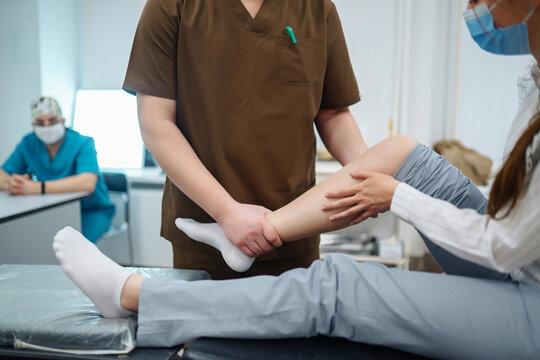 Patient visits a doctor after suffering a leg injury. The doctor examines the patient, examines the picture of the patient. Osteopathy, chiropractic, leg correction, rehabilitation.