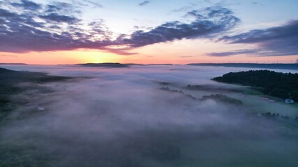 Beautiful view of a forest covered with clouds during sunset