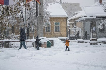 Group of people walking outside in snow storm - winter magic