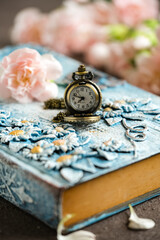 still life pocket watch on  a book
