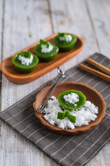 kue lumpang or kue ijo, kue kosui is Indoensian traditional cake made from rice flour, tapioca and juice pandanus, eaten with grated coconut

