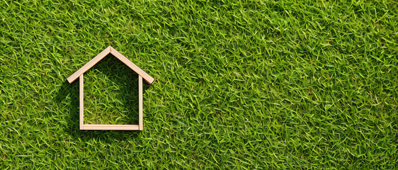 Miniature model of a wooden house on a meadow, the concept of suburban real estate in the village. Generative AI.