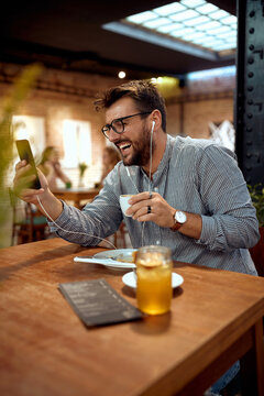 man drinking a coffee and havinh fun looking at his phone