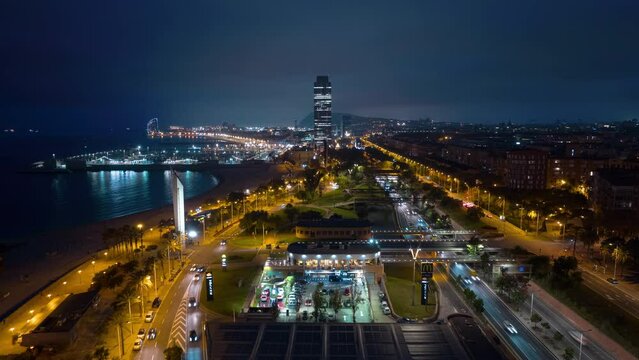 night illuminated flight over barcelona city famous crowded beach traffic bay aerial panorama 4k timelapse spain