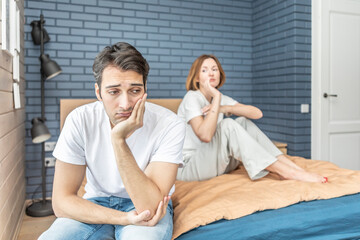 Fototapeta premium Frustrated and depressed man sitting on the edge of the bed after conflict with his wife because of his erectile dysfunction problem