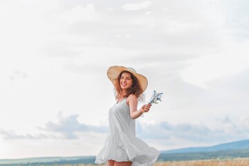 Fototapeta na wymiar Woman in a hat on field wheat background