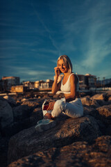 A Stunning Woman Enjoys the Tranquil Sunset by the Sparkling Sea, Embracing the Calming Moment of Nature's Majesty