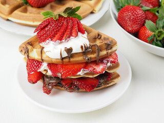 Viennese waffles decorated  with strawberries, chocolate and whipped cream