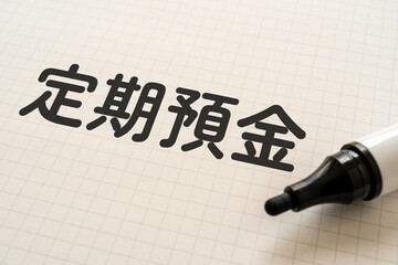 定期預金と書かれたノートとマーカー