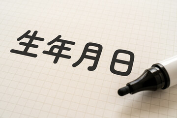 生年月日と書かれたノートとマーカー