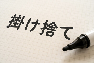 掛け捨てと書かれたノートとマーカー