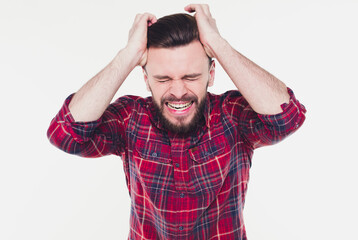 Naklejka premium Young man wearing checkered shirt standing over isolated white background crazy and mad shouting and yelling with aggressive expression and arms raised. Frustration concept.