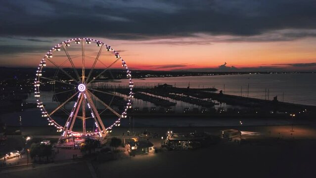 aerial view from the drone of the wonderful and immense ferris wheel of Rimini at sunset. You can also see the entire Romagna coast.