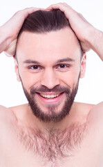 Obraz premium Handsome, attractive, brutal, modern, manly, confident, naked man touching his perfect, ideal face skin, looking at camera and posing isolated on white background after bath