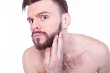 Fototapeta premium Handsome, attractive, brutal, modern, manly, confident, naked man touching his perfect, ideal face skin, looking at camera and posing isolated on white background after bath