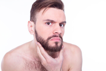 Obraz premium Handsome, attractive, brutal, modern, manly, confident, naked man touching his perfect, ideal face skin, looking at camera and posing isolated on white background after bath