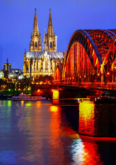 Famous Cologne Cathedral in night, bridge and river Rhine and reflcetions in water
