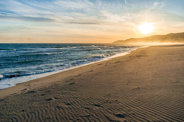 CINEMATIC SUNSET ON SAND AT THE BEACH WITH WAVES LOW CONTRAST