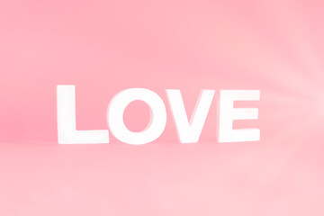 Word LOVE on pink pastel background.