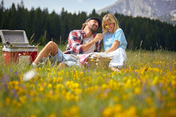 A young couple enjoying in picnic on the meadow in the nature. Relationship, love, nature, activity